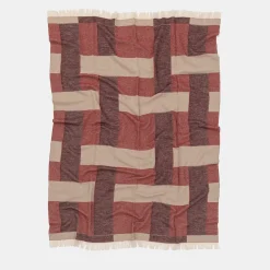 Coperta rossa con frange e motivi intrecciati