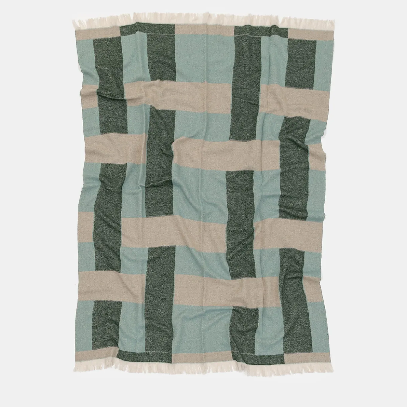 Coperta verde con frange e motivi intrecciati