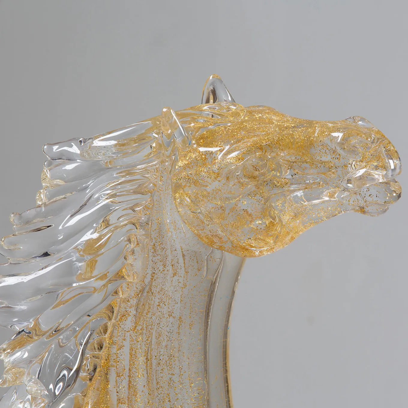 Piccolo cavallo seduto in vetro dorato